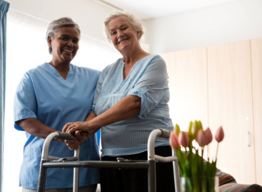 caregiver and a senior woman smiling